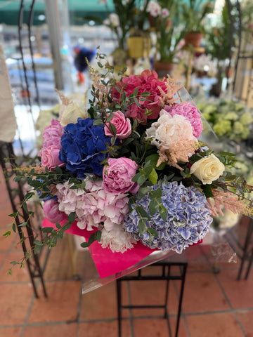 Punch H full view: blue, lilac and pink hydrangea, pink peonies, pink and cream roses and astilbe in hot pink paper