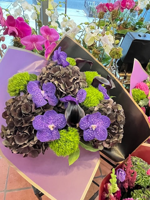 Dark Love, medium size: dark antique hydrangea, purple vanda orchids, green dianthus and a dark calla lily in lavender wrap