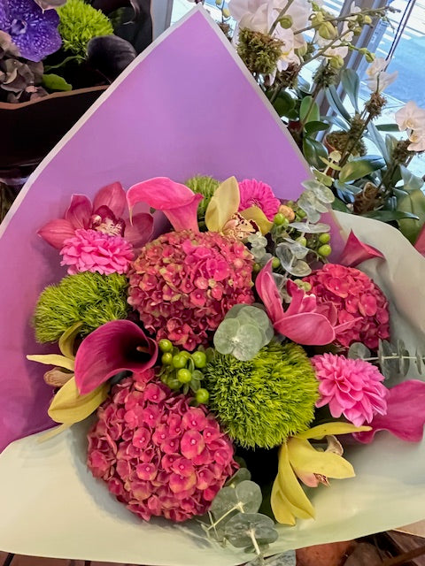 Hy Love from above: pink hydrangea, callas and dahlias with yellow-green cymbidium orchids and green hypericum berries