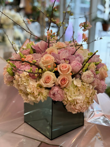Pink Fury, large size, peach roses, pink peonies and cymbidium orchids with flowering branches in a mirrored cube