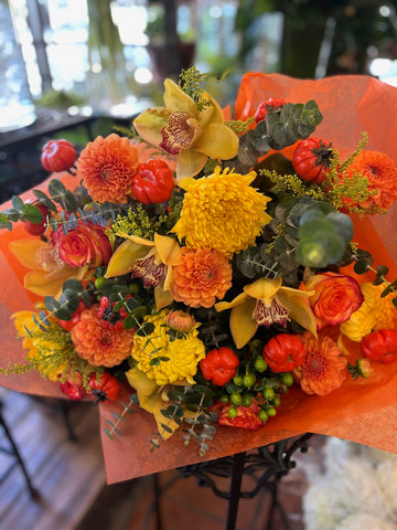Fall in Love: orange dahlias, yellow cymbidium orchids, yellow mums, orange roses and mini pumpkins in orange wrap