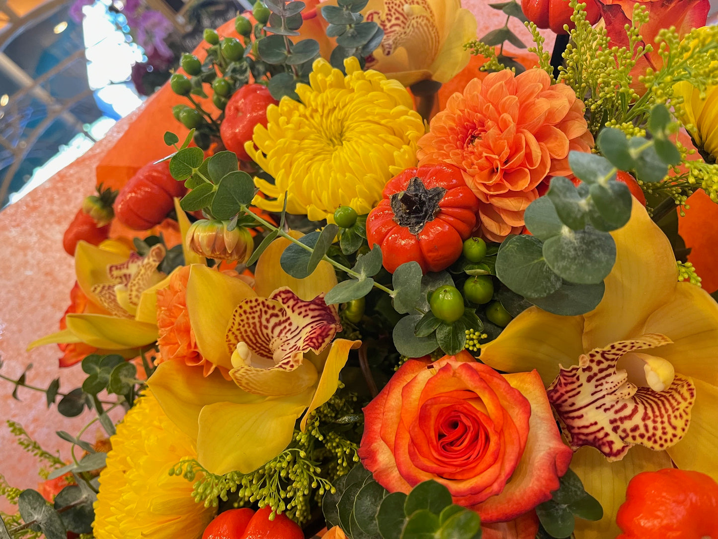 Fall in Love, small without vase: close-up of a yellow cymbidium orchid, orange rose, dahlia, yellow mum and mini pumpkin