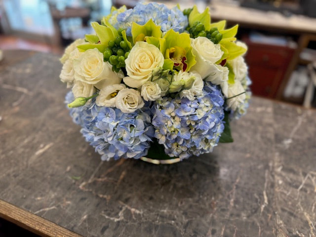 Blue Dream round bowl version from a high angle: white roses and lisianthus with green orchids over blue hydrangea