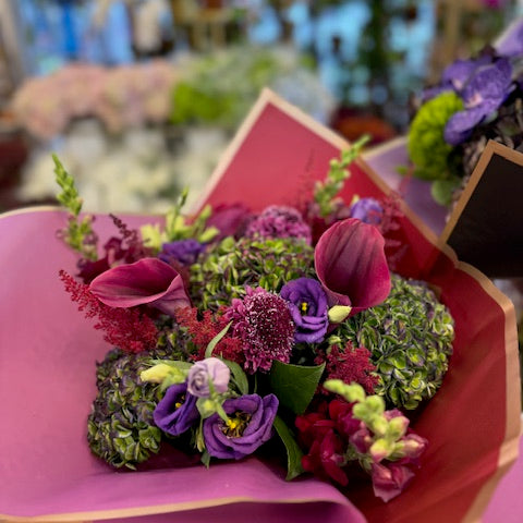 Green Envy: green antique hydrangea, burgundy calla lilies, purple lisianthus, scabiosa and astilbe in magenta wrap