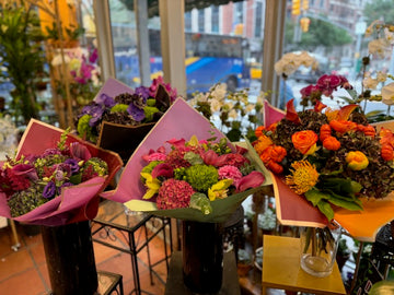 Hy Love large size, center, in the shop window between a purple bouquet and an orange fall bouquet, lavender wrap