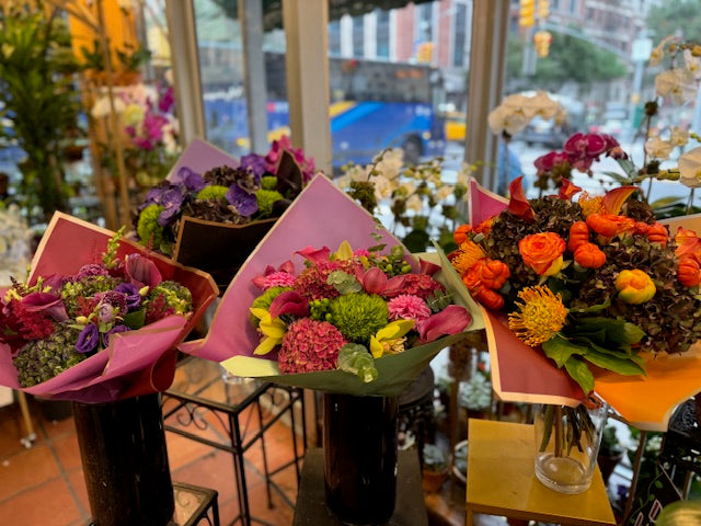 Hy Love large size, center, in the shop window between a purple bouquet and an orange fall bouquet, lavender wrap