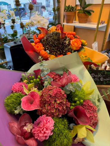 Hy Love medium size: pink hydrangea, callas, dahlias and cymbidium orchids, with an orange fall bouquet behind