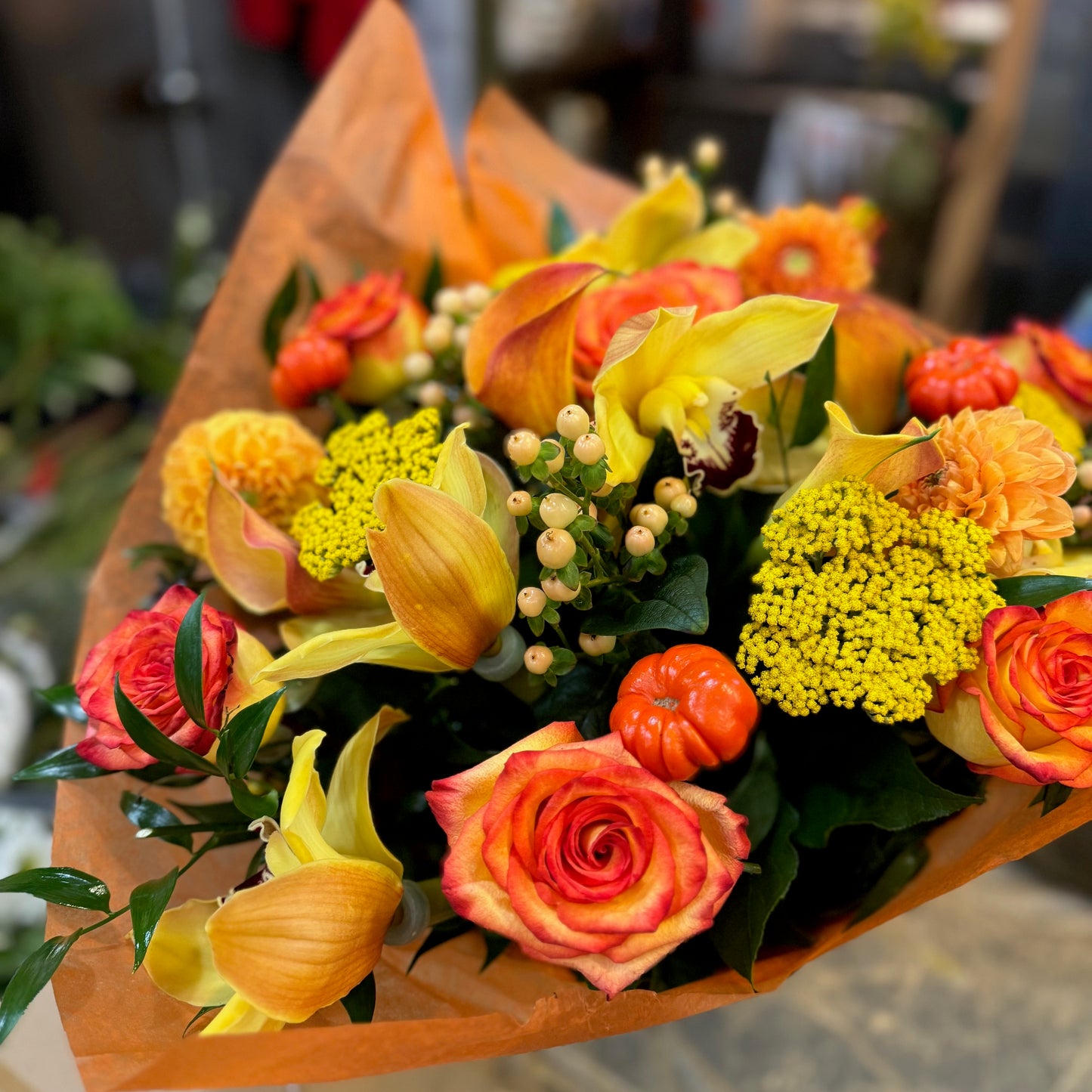 Fall in Love, medium with vase: orange roses, yellow callas, yarrow, a cymbidium orchid and mini pumpkins in orange wrap