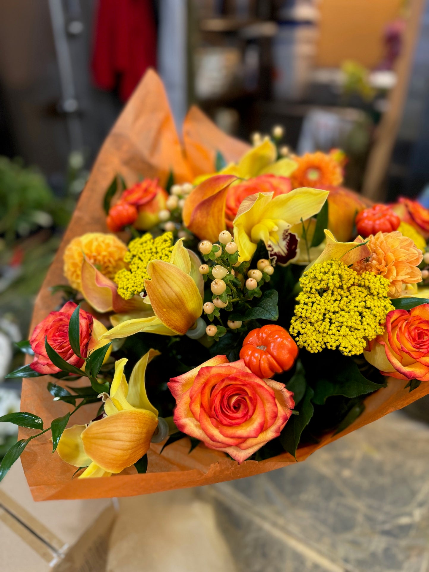 Fall in Love, medium with vase: orange roses, yellow callas, yarrow, a cymbidium orchid and mini pumpkins in orange wrap
