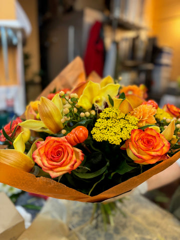 Fall in Love, small with vase: bicolor orange roses, yellow calla lilies, yarrow and cream hypericum berries in orange paper