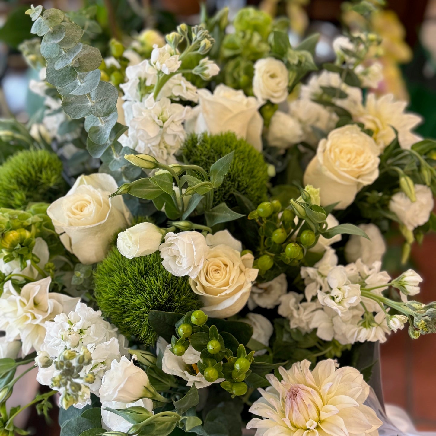 Erly Afternoon, medium with vase: white roses, white dahlia, stock, green dianthus, hypericum berries and eucalyptus