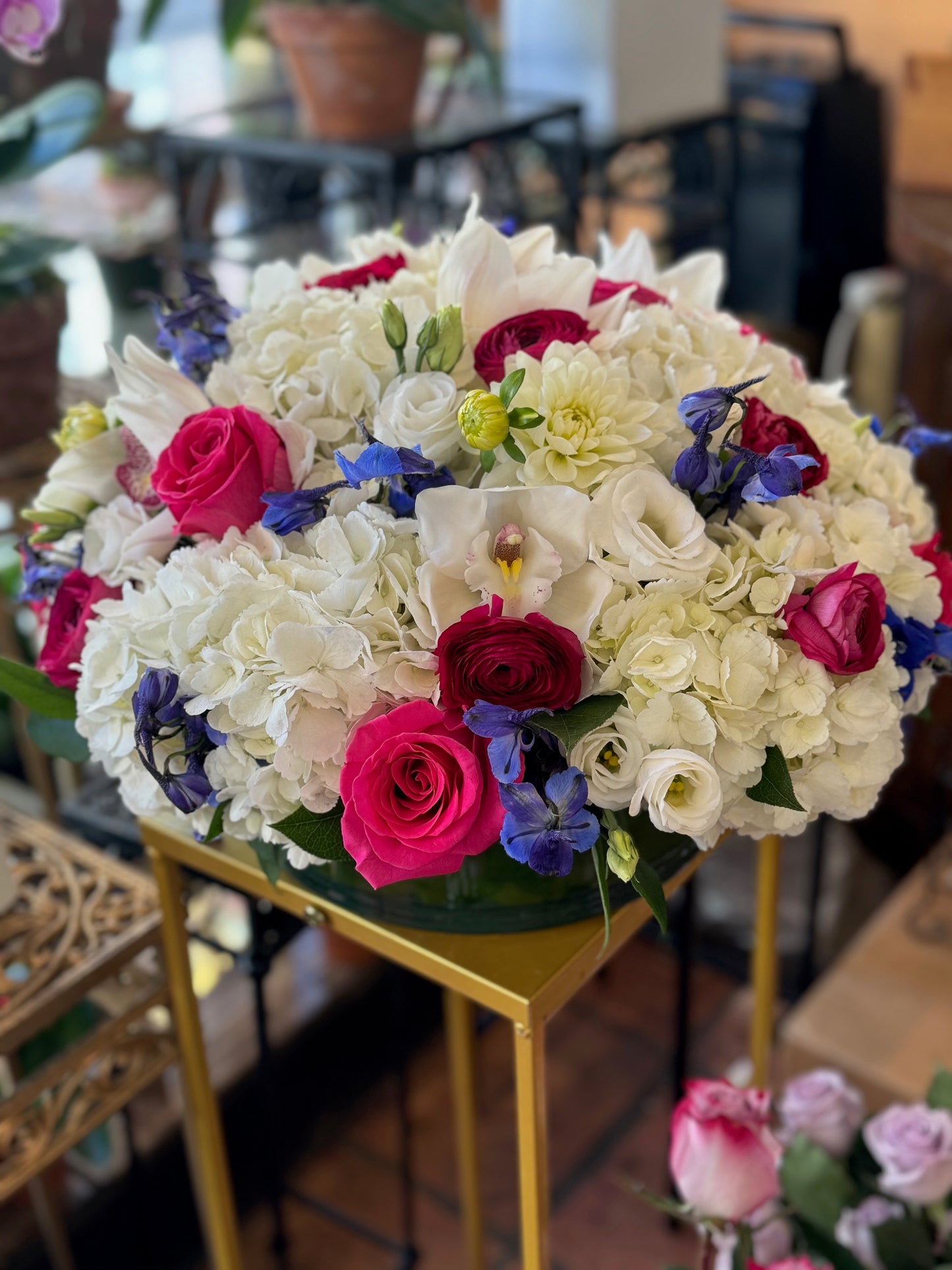 White Fire large size, white hydrangea and cymbidium orchids with hot pink roses, red ranunculus and blue delphinium