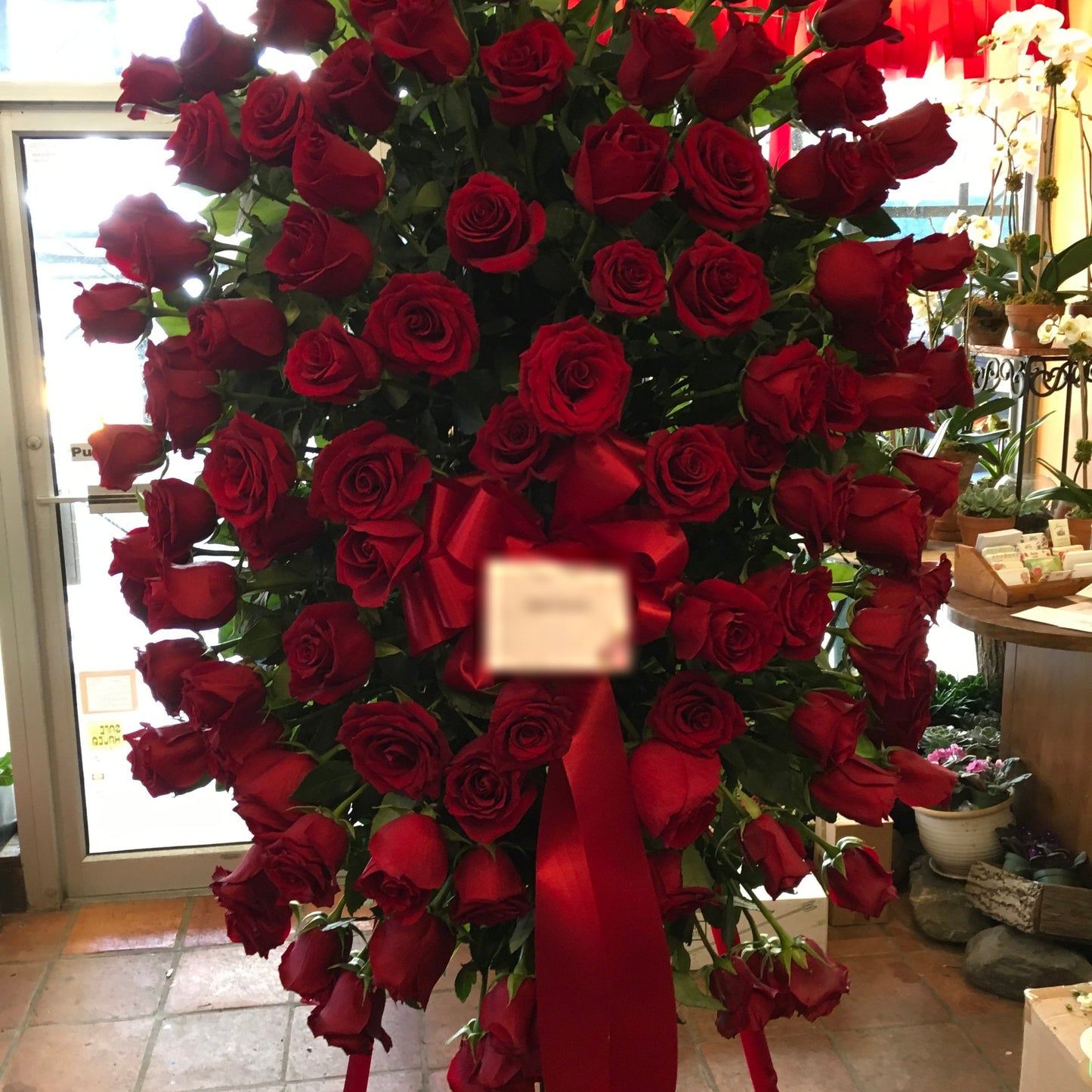Tranquil roses sympathy spray with red roses on easel - Jerome Florists NYC