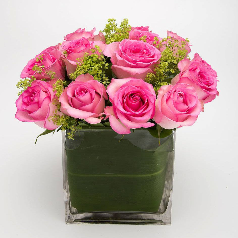 Dash of Pink: medium pink roses with lime green lady's mantle in a leaf-lined glass cube vase