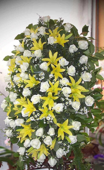 Tranquility small size, spray of white roses, yellow lilies and small white daisies with greenery