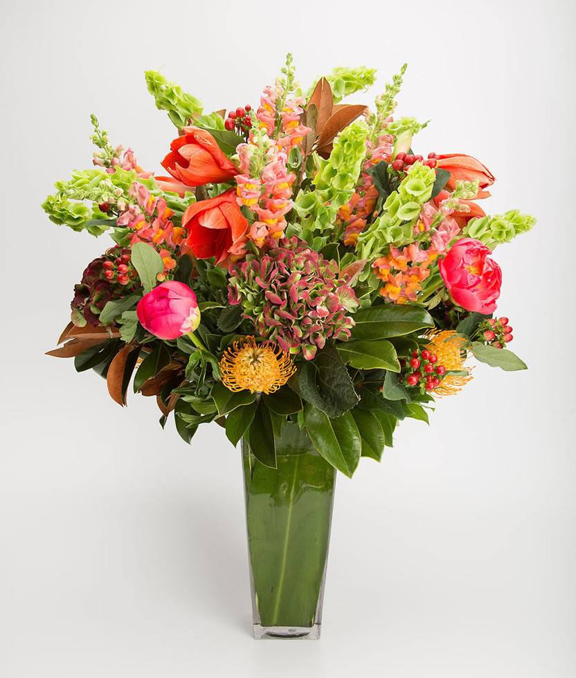 Tall orange amaryllis with coral snapdragons, bells of Ireland and hydrangea