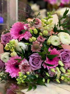 Hand-tied bouquet of pink gerbera daisies, lavender roses and white ranunculus