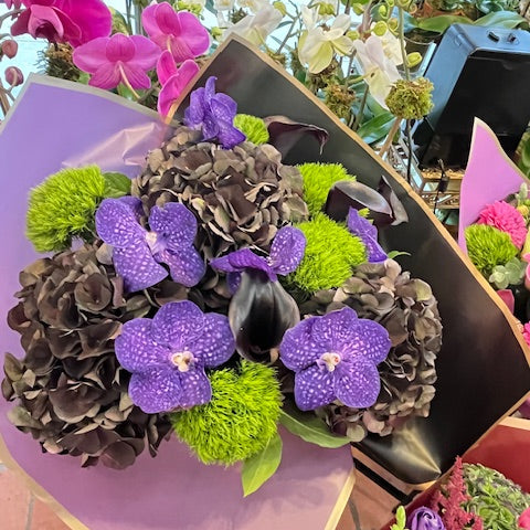 Dark Love, medium size: dark antique hydrangea, purple vanda orchids, green dianthus and a dark calla lily in lavender wrap