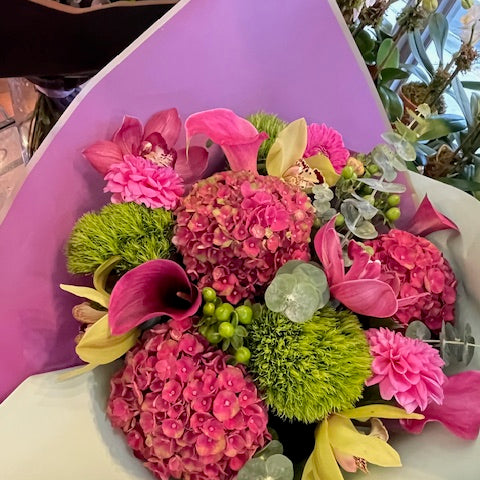 Hy Love bouquet of raspberry hydrangea, pink callas, cymbidium orchids, pink dahlias and green dianthus in lavender wrap