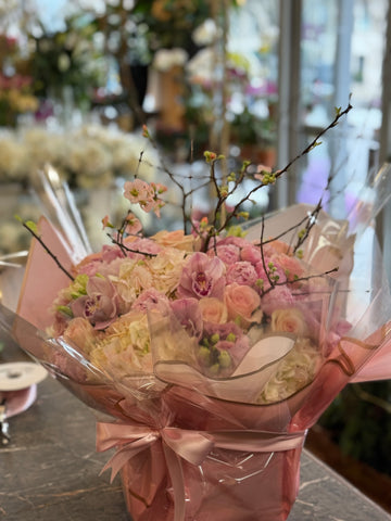 
                    
                      Pink Fury, medium size, wrapped in pink cellophane with a ribbon, showing pink orchids, roses and hydrangea
                    
                  