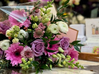 
                    
                      Good Vibes, With Vase option: lavender roses, pink gerberas, white ranunculus and lime snapdragons lying on the counter
                    
                  