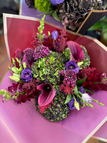
                    
                      Green Envy with burgundy callas, purple lisianthus and scabiosa over green hydrangea, Dark Love bouquet behind
                    
                  