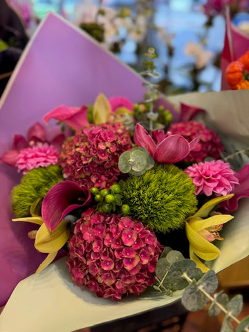 
                    
                      Hy Love close-up of pink antique hydrangea, magenta calla lilies, yellow cymbidium orchids and green dianthus
                    
                  