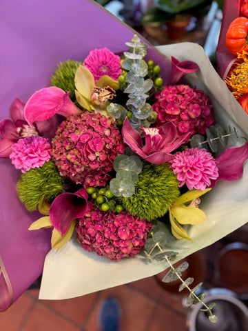 
                    
                      Hy Love top view: pink hydrangea, pink dahlias, pink and yellow cymbidium orchids and eucalyptus in mint and lavender paper
                    
                  
