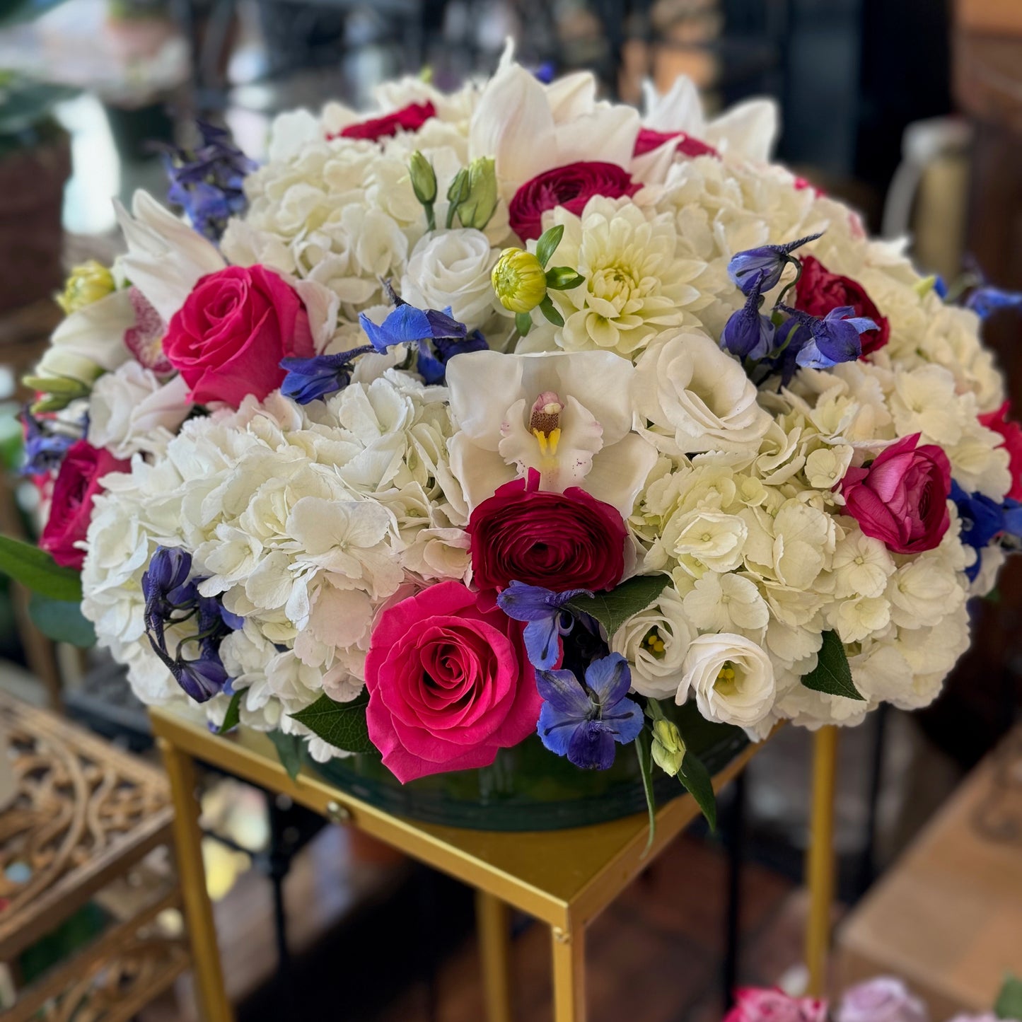 White Fire large size, white hydrangea and cymbidium orchids with hot pink roses, red ranunculus and blue delphinium