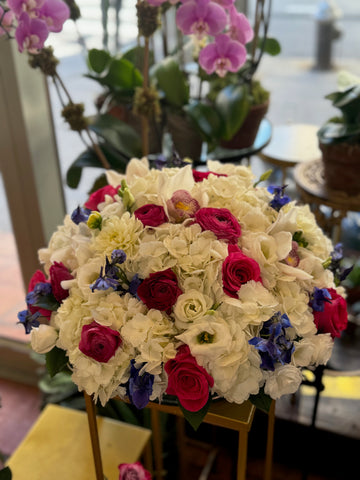 
                    
                      White Fire medium size, white hydrangea dome with blush and white cymbidiums, hot pink roses, ranunculus and delphinium
                    
                  