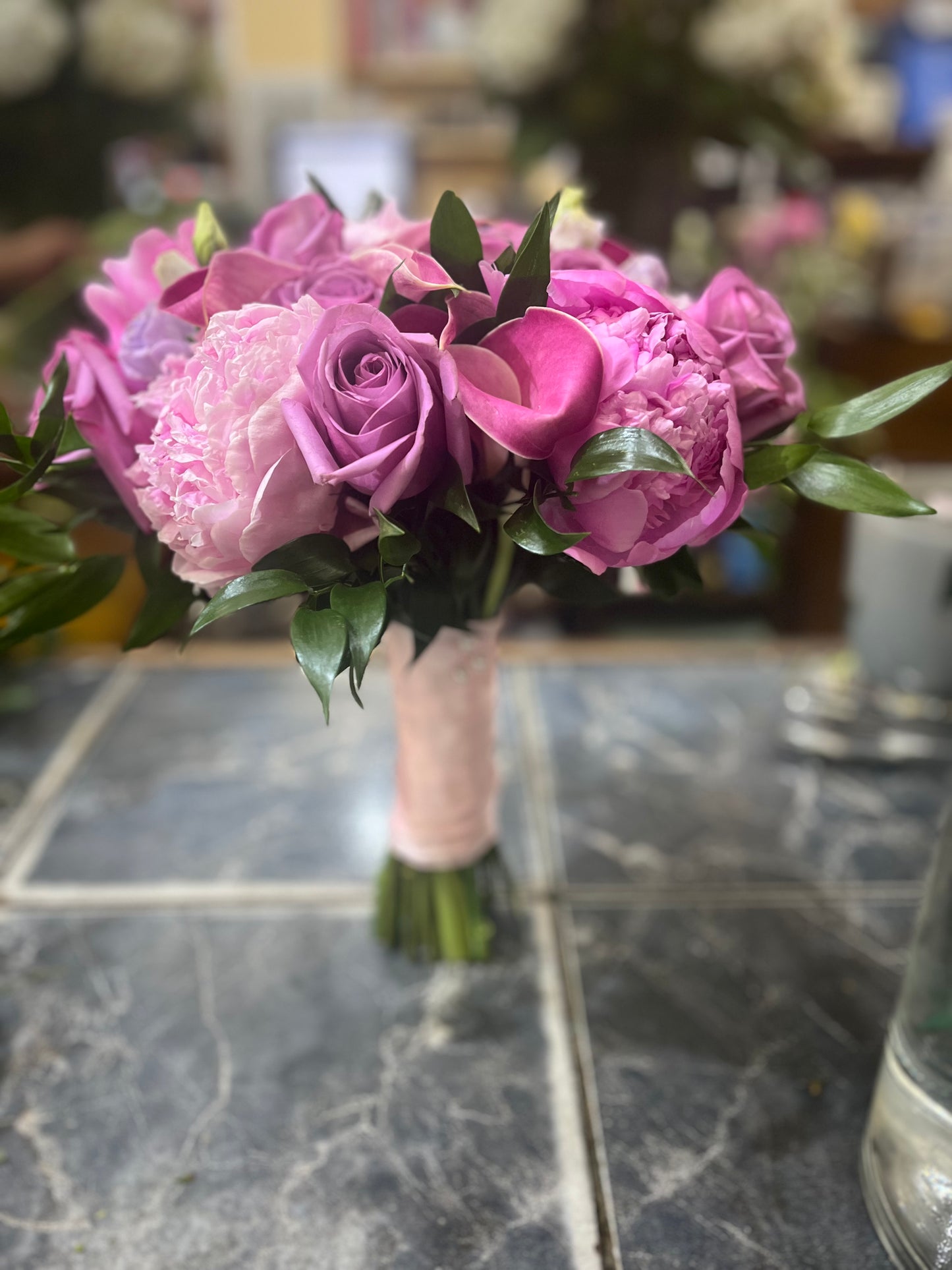 
                  
                    Bouquet of pink and purple flowers on a marble surface
                  
                