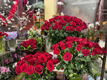 
                    
                      Complete Love: a black-wrapped red rose bouquet beside three glass vases of long-stem red roses
                    
                  